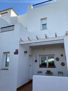 奇克拉纳－德拉弗龙特拉Precioso adosado rodeado de un entorno verde natural y muy cerca de la playa的白色的房子,有白色的墙壁和窗户