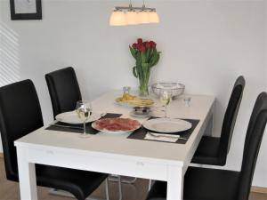 巴登-巴登Appartement Panoramablick的白色的餐桌,配有黑色椅子和酒杯