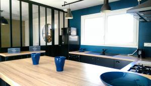 弗雷埃勒L'Atelier的厨房配有带蓝杯的木桌