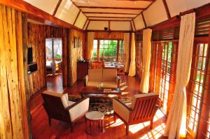 奈瓦沙Muthu Lake Naivasha Country Club, Naivasha的客厅配有椅子、电视和窗户