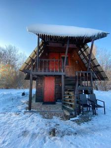VecumniekiPirts namiņš Zvaniņi的雪中带红门的小木屋