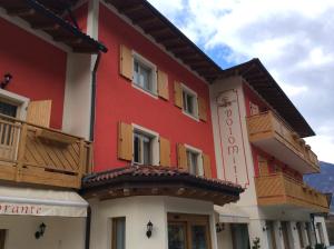 蒂奥内迪特伦托多洛米蒂索恩酒店的红色和白色的建筑,设有木制阳台
