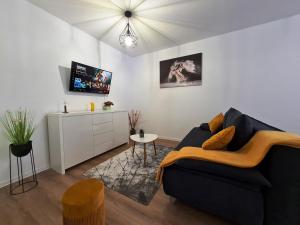 奥拉迪亚Apartament Luca P4B Oradea Prima Residence的客厅配有黑色沙发和电视