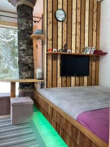KohilaTiigrisilma Treehouse的卧室配有一张床,墙上挂着一个钟