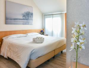 米兰奇马罗萨住宿酒店的一间卧室配有一张带白色床单和花瓶的床。
