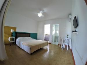弗洛里亚诺波利斯弗洛里帕冲浪旅馆的卧室配有一张床和一张桌子及椅子
