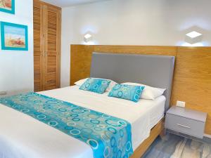 博卡奇卡Hotel Agua Dulce的一间卧室配有白色床和蓝色枕头