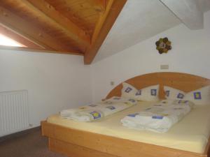 施图拜河谷新施蒂夫特Alpenhaus Christian的一间卧室配有一张带毛巾的木床