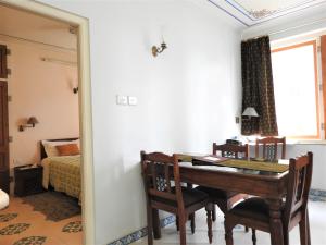 斋浦尔欧姆尼瓦斯套房酒店的一间带桌子的用餐室和一间卧室
