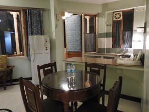斋浦尔欧姆尼瓦斯套房酒店的一间带桌子的厨房和一间带冰箱的厨房