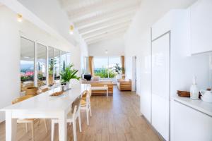 阿尔米里达Almyrida Sands的白色的厨房和配有白色桌椅的用餐室