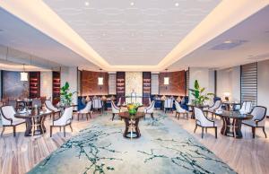 杭州杭州明豪voco酒店，洲际酒店集团旗下的餐厅的 ⁇ 染,配有桌椅