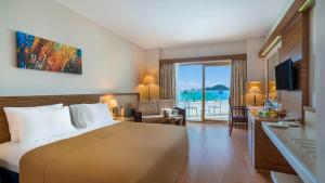 图尔古特雷斯Azure By Yelken Hotel的酒店客房设有一张床,享有海景。