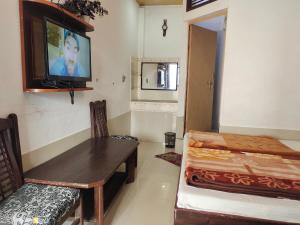 Fatehpur Sīkri温达文酒店的一间设有桌子和墙上电视的房间