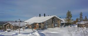 萨利色尔卡Sielikkö Aurora Log Apartments的小木屋顶部有雪