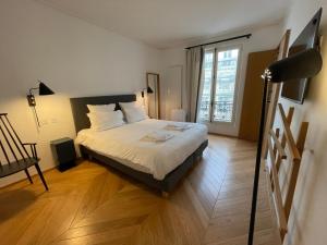 巴黎RESIDENCES HARCOURT - Ile Saint Louis - PARIS的一间卧室设有一张床和一个大窗户