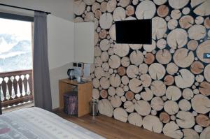 圣斯特凡诺迪凯德Locanda La Baita的一间卧室设有覆盖在原木上的墙壁