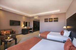 马拉喀什凯克精品酒店&Spa的酒店客房,设有两张床和一张沙发