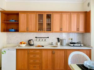 锡德梅利莎花园公寓酒店的厨房配有木制橱柜和白色冰箱。