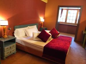 布勒伊-切尔维尼亚Hotel Punta Maquignaz的一间卧室配有一张带红色枕头的床和一扇窗户