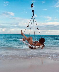 弗里德胡岛屿度假宾馆的坐在海滩吊床上的女人