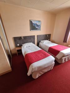 米拉HOSTELLERIE du CANTAL的红地毯旅馆客房的两张床