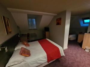 米拉HOSTELLERIE du CANTAL的酒店客房的床铺配有红色和白色的床单
