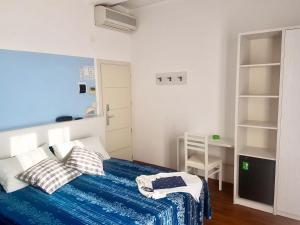 里米尼Hotel Arena的一间卧室配有一张带蓝色床单和枕头的床。