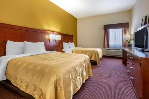 泽弗希尔斯Quality Inn Zephyrhills-Dade City的酒店客房设有两张床和一台平面电视。