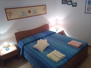卡布拉斯斯特拉玛琳娜酒店的一间卧室配有蓝色的床和两个枕头