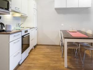拉赫登佩拉Holiday Home Kerttu by Interhome的厨房配有白色橱柜和桌椅