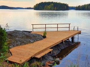 LuopioinenHoliday Home Rihka by Interhome的湖面上带长凳的木甲板