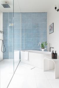 米兰BMORE Duomo - Luxury Apartments near Duomo的带浴缸和玻璃淋浴间的浴室。