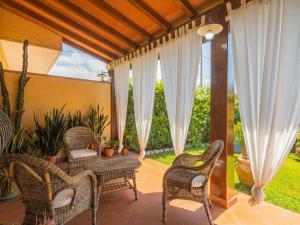 彼得拉桑塔Holiday Home Renza by Interhome的露台设有藤椅和门廊上的桌子