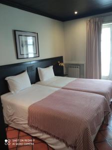 布拉加森霍拉布兰卡酒店的卧室内两张并排的床