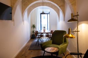 瓦莱塔Guest House de la Valette的客厅配有绿色椅子和桌子