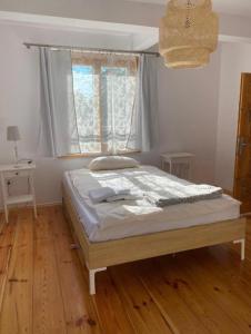 谢米亚蒂切Moje Podlasie - Dom w Siemichoczach的卧室内的一张床位,铺有木地板
