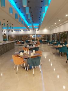 吉赞贾赞假日酒店的一间带桌椅和蓝光的餐厅