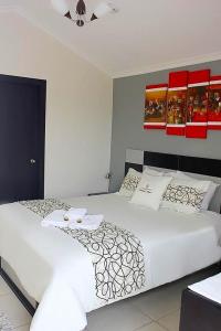 塔巴贝拉塔巴贝拉兰德酒店的一间卧室配有两张带白色床单的床
