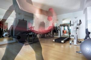 梅加利阿莫斯Aegean Suites的一间设有红色椅子和跑步机的健身房