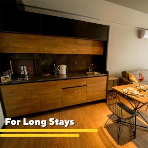 开塞利The Kayseri Loft Hotel的一间带木制橱柜和桌子的厨房以及一间用餐室
