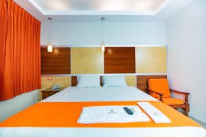 塔拉波托Hotel Nilas的一间卧室配有一张带橙色毯子的床
