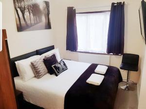 恩菲尔德The 55的卧室配有带枕头的床铺和窗户。