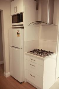 北哈夫洛克Apartment on St Georges的白色的厨房配有炉灶 冰箱旁的顶级烤箱