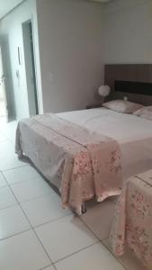 卡达斯诺瓦斯Lagoa Quente Flat Service的一间卧室配有一张带粉红色床单的大床