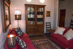 卢卡Il Carmine Charme & Terrace with AC的客厅配有2张红色沙发和书柜