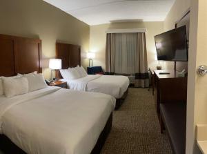 西米夫林Wingate by Wyndham Pittsburgh West Mifflin的酒店客房设有两张床和一台平面电视。