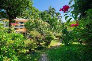 三亚三亚南中国大酒店的一座花园,在一座建筑前种有树木和花卉
