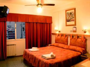 布宜诺斯艾利斯格兰大西洋酒店的一间卧室配有一张床,上面有两条毛巾