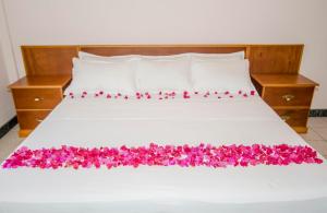 圣约翰斯加勒比套房酒店的一张带粉红色花的床铺
